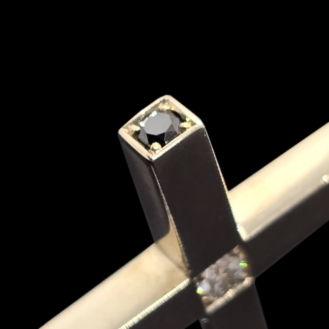 Balto aukso kryželis su baltais ir juodais deimantais